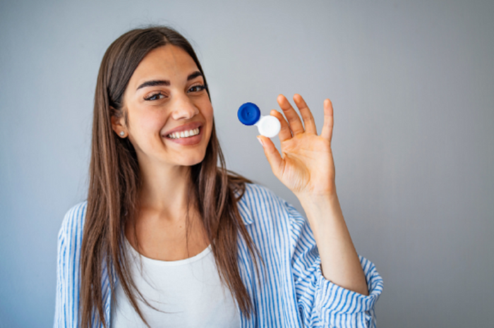Mujer mostrando lentes de contacto toricos