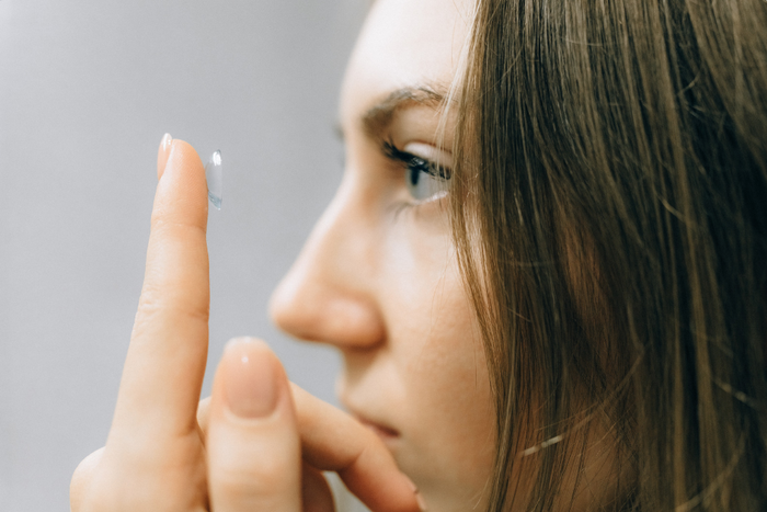 mujer colocándose lentes de contacto